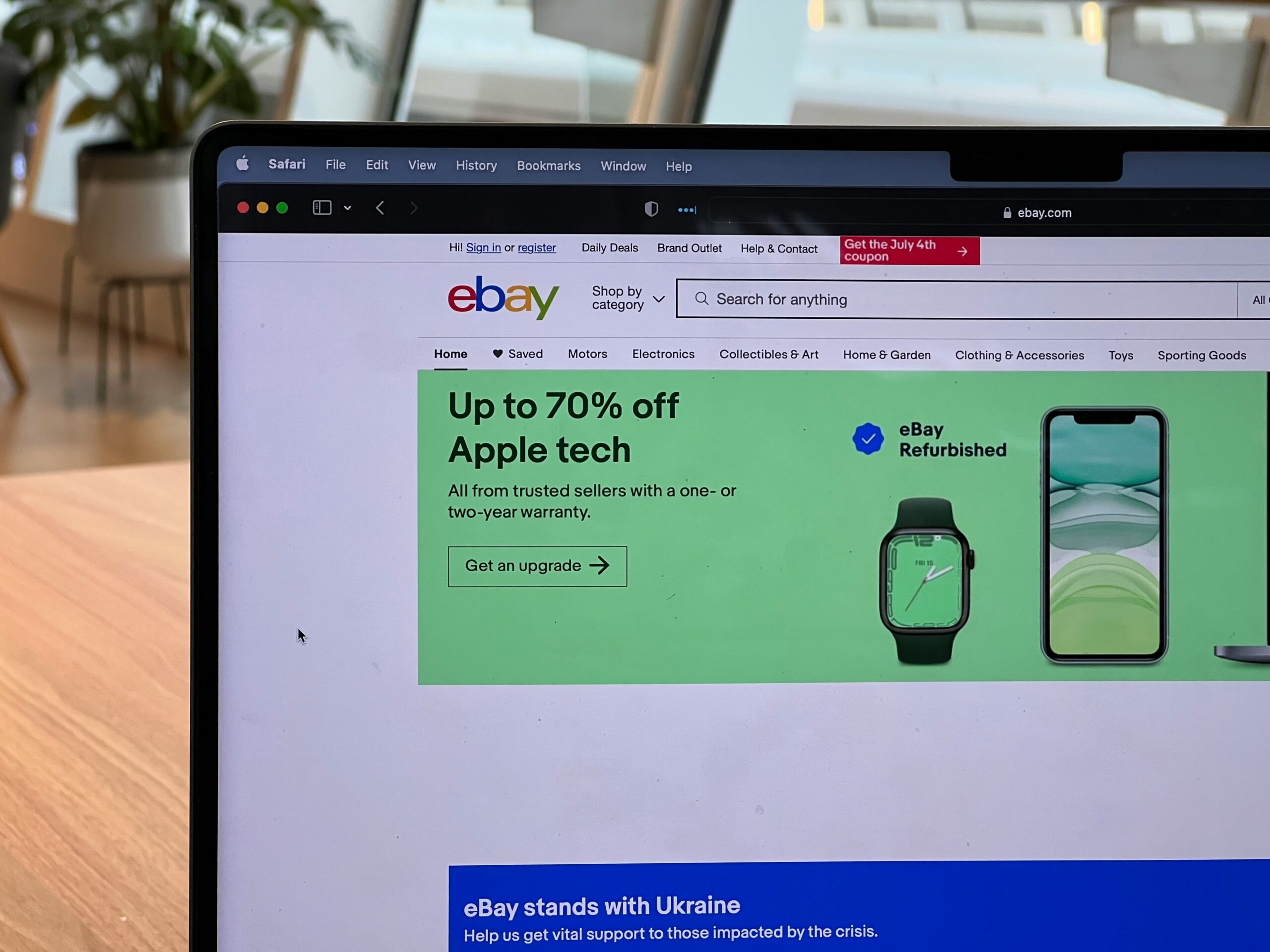 Laptop screen showing the eBay homepage with a refurbished tech promotion